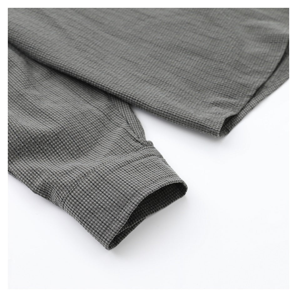 Close-up of gray micro-check shirt sleeves and buttonless cuffs.