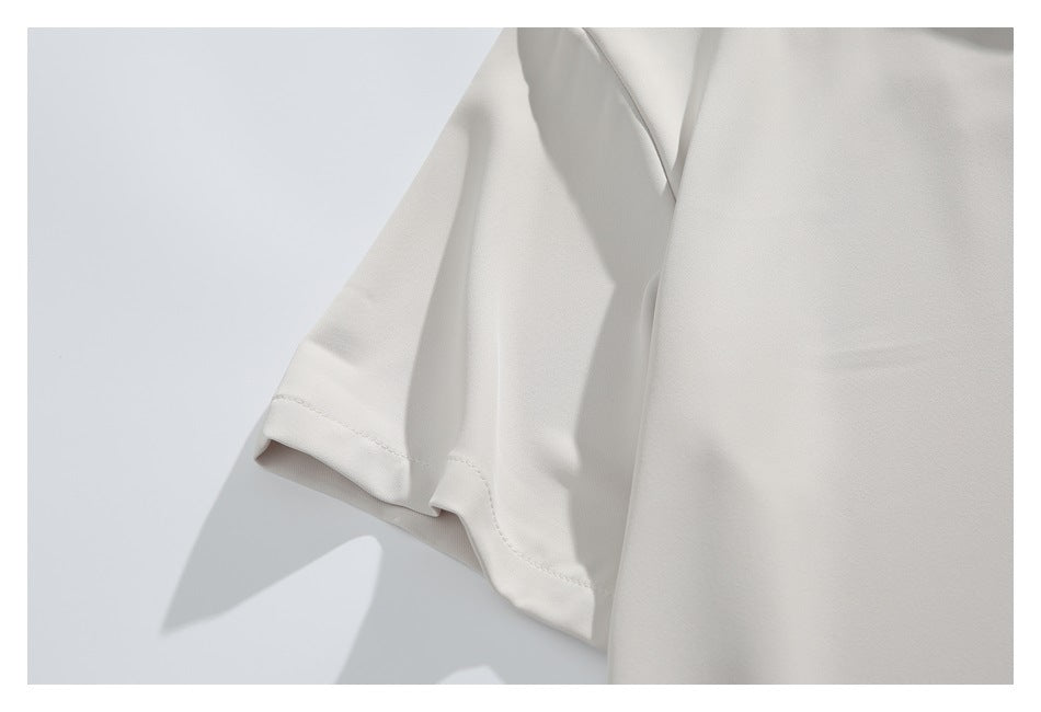 Close-up of the ivory shirt's short sleeve and stitched hem.