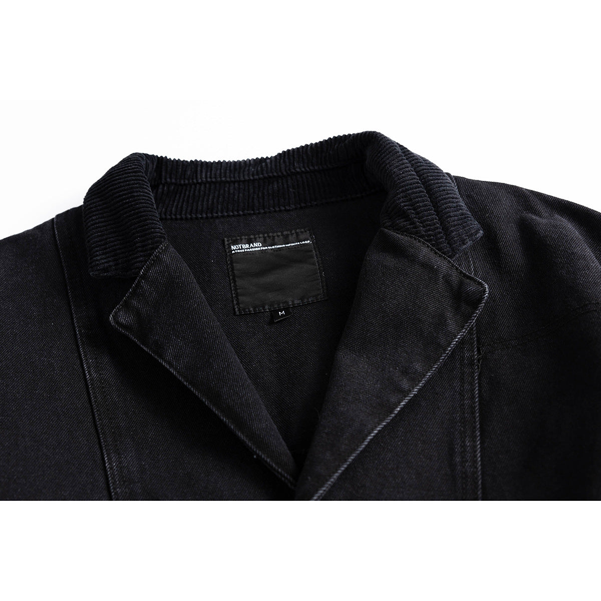 Close-up of a black jacket's ribbed collar, lapels, and sewn neck label.