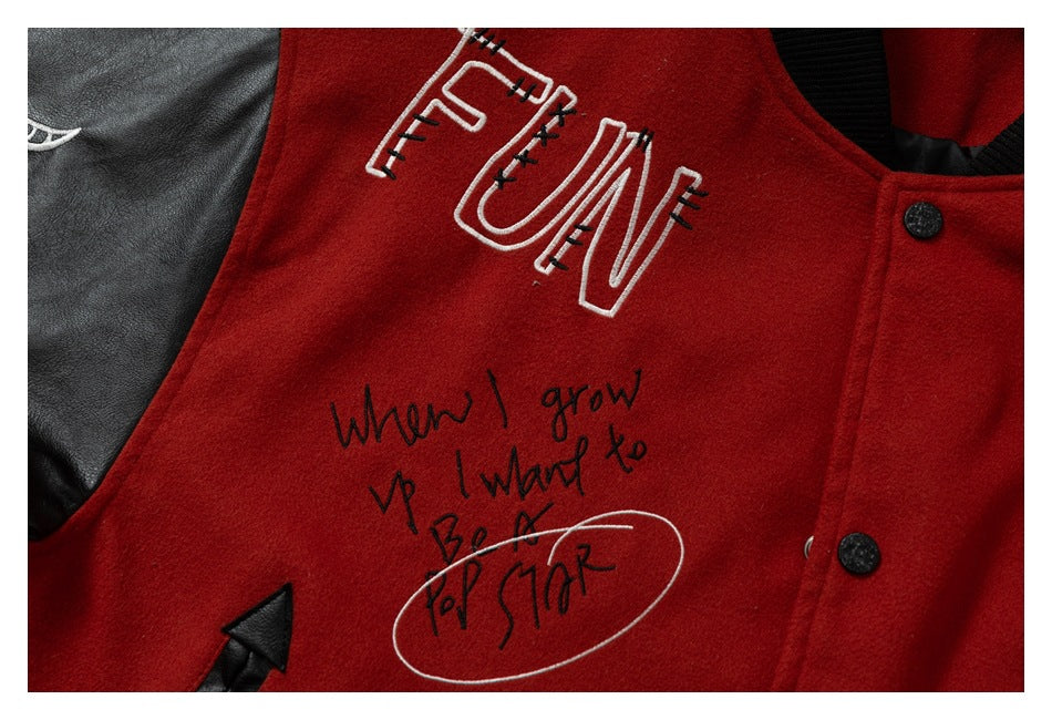 Close-up of white and black lettering on the red jacket front beside a black sleeve and snap buttons.