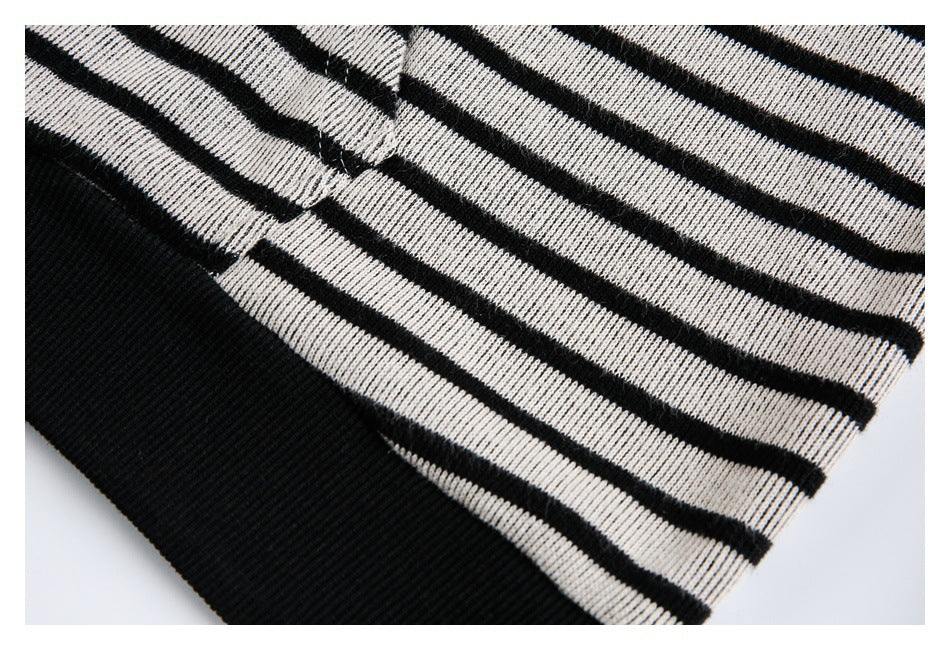 Close-up of black-and-white striped knit fabric meeting a wide black ribbed edge.