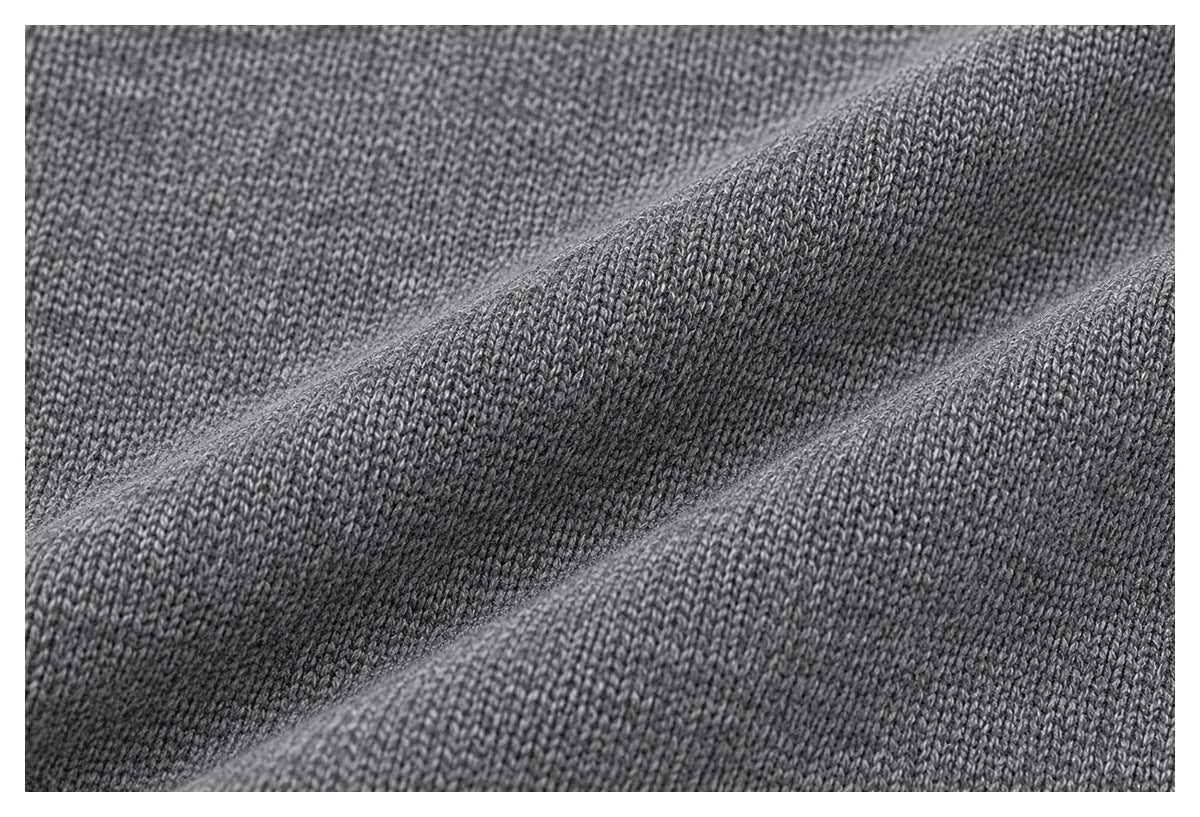 Close-up of gray knit fabric draped in soft folds, showing its fine stitch texture.