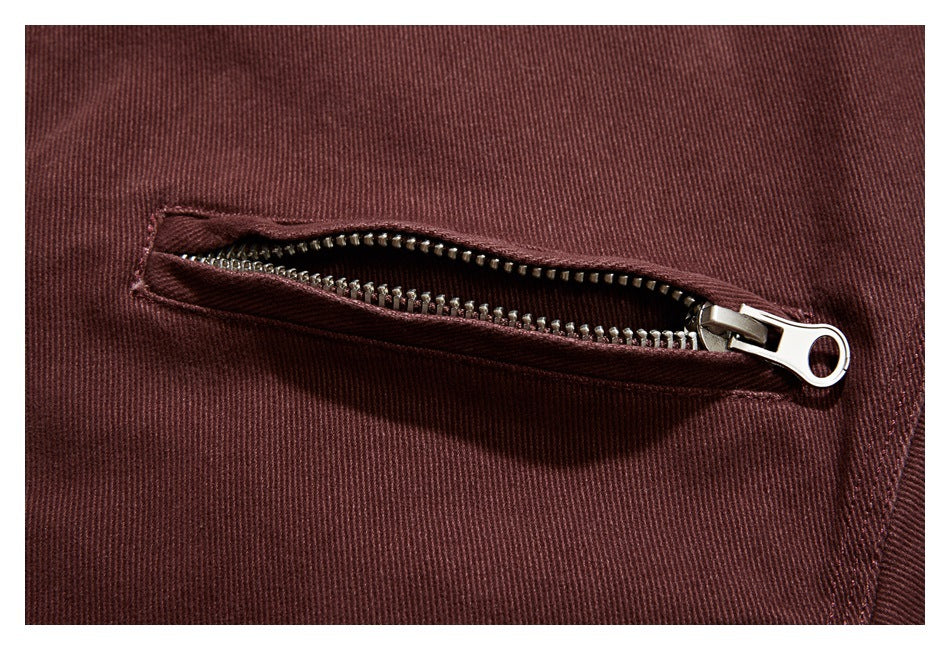 Close-up of an open metal zipper pocket on the burgundy jacket.