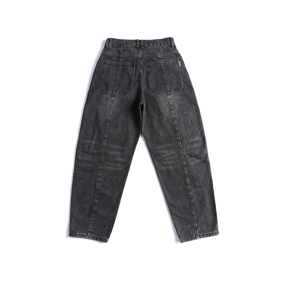 Back view of black-gray washed jeans with two patch pockets and vertical seams, flat lay