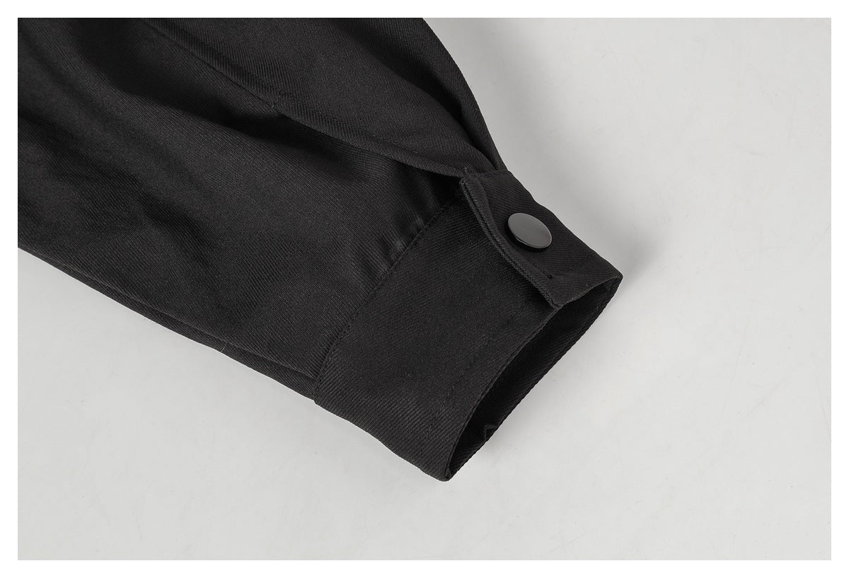 Close-up of a black sleeve cuff with a dark snap button.