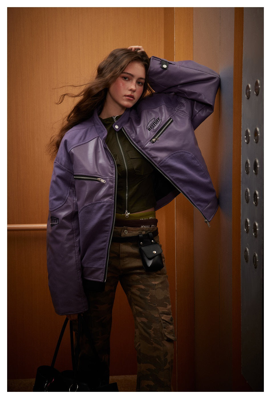 Model in open purple racer jacket with chest zip pocket, sleeve patch and camouflage cargo pants