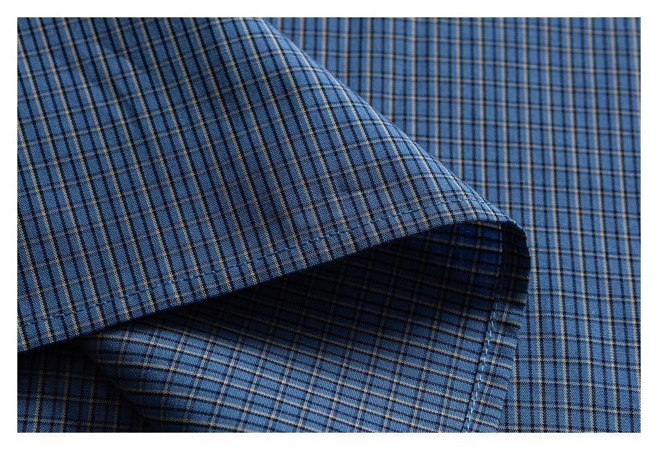 Close-up of a blue plaid shirt cuff folded over matching fabric.