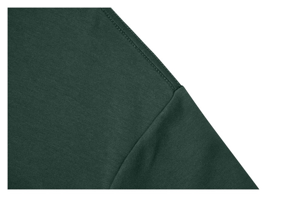 Close-up of the dark green T-shirt's shoulder and sleeve seam.