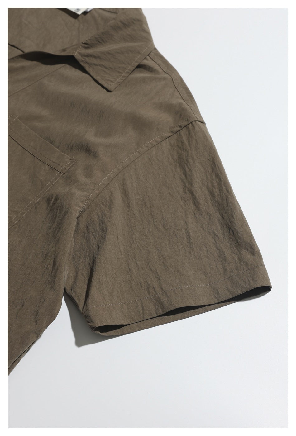 Close-up of the brown shirt's short sleeve, shoulder seam, and part of its chest pocket.
