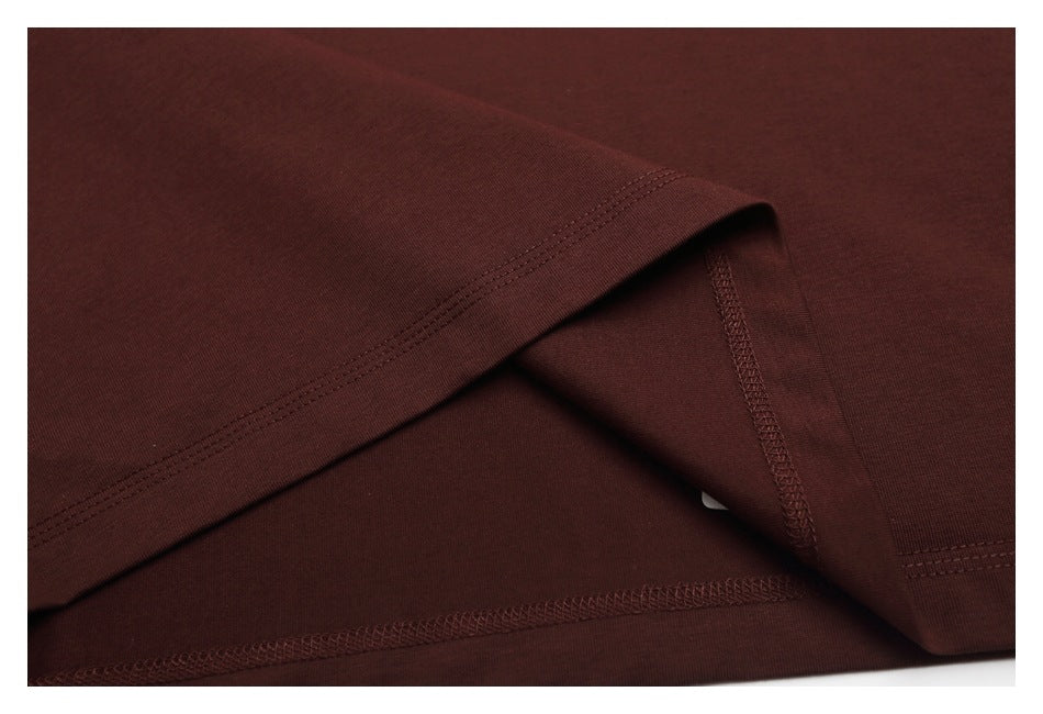 Close-up of the dark brown T-shirt's hem and interior overlock seams.