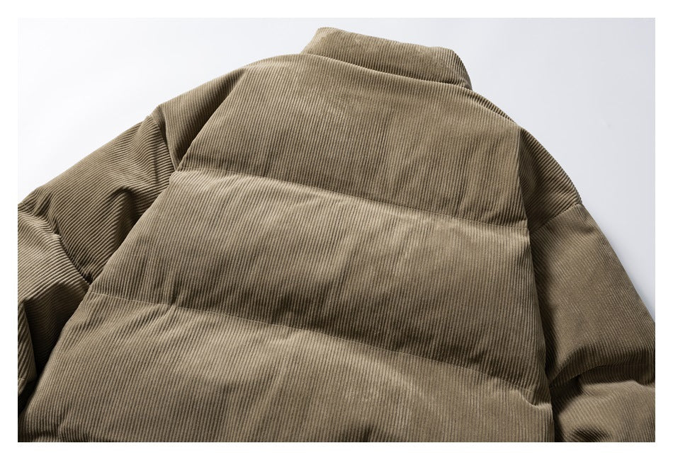 Close-up of an olive-brown corduroy padded jacket, showing its collar and horizontal quilted panels.