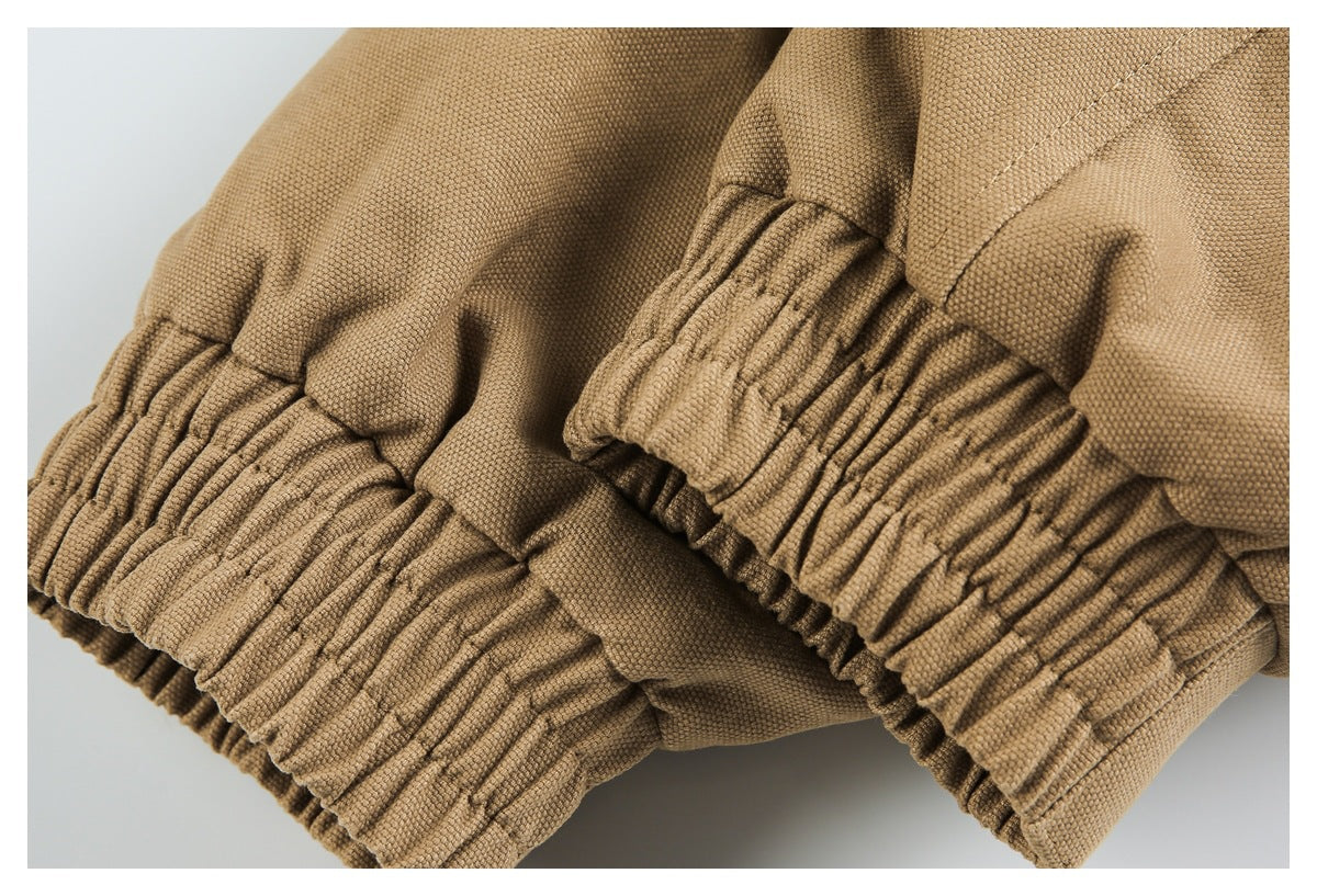 Close-up of tan fabric and gathered elastic cuffs with visible stitching.