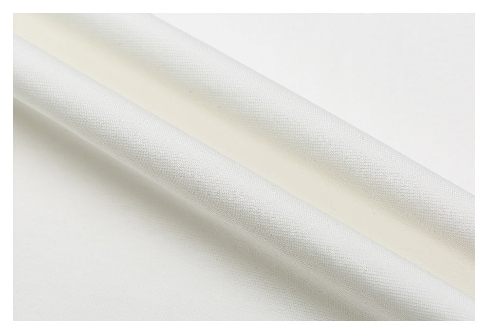 Close-up of white T-shirt fabric draped in soft folds, showing its surface texture.