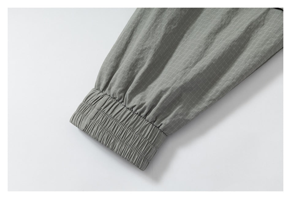 Close-up of an elasticized cuff on gray grid-patterned fabric.