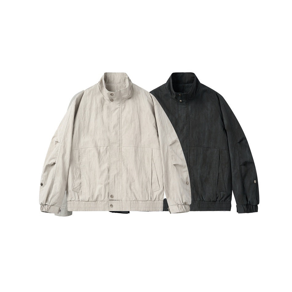 Front view of two jackets: one light gray-beige and one black, both with stand collars and snap details.
