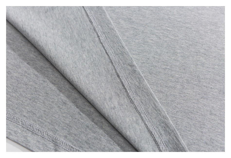 Close-up of gray knit fabric showing a diagonal seam with overlock stitching.