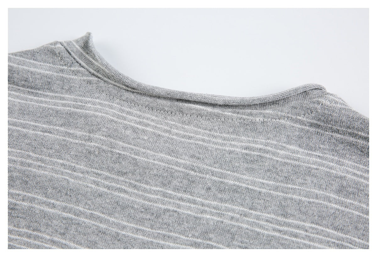 Close-up of the rounded neckline on a gray knit garment with thin white stripes.