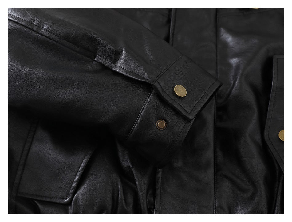 Close-up of a black jacket sleeve cuff with a brass-colored snap and a flap pocket nearby.