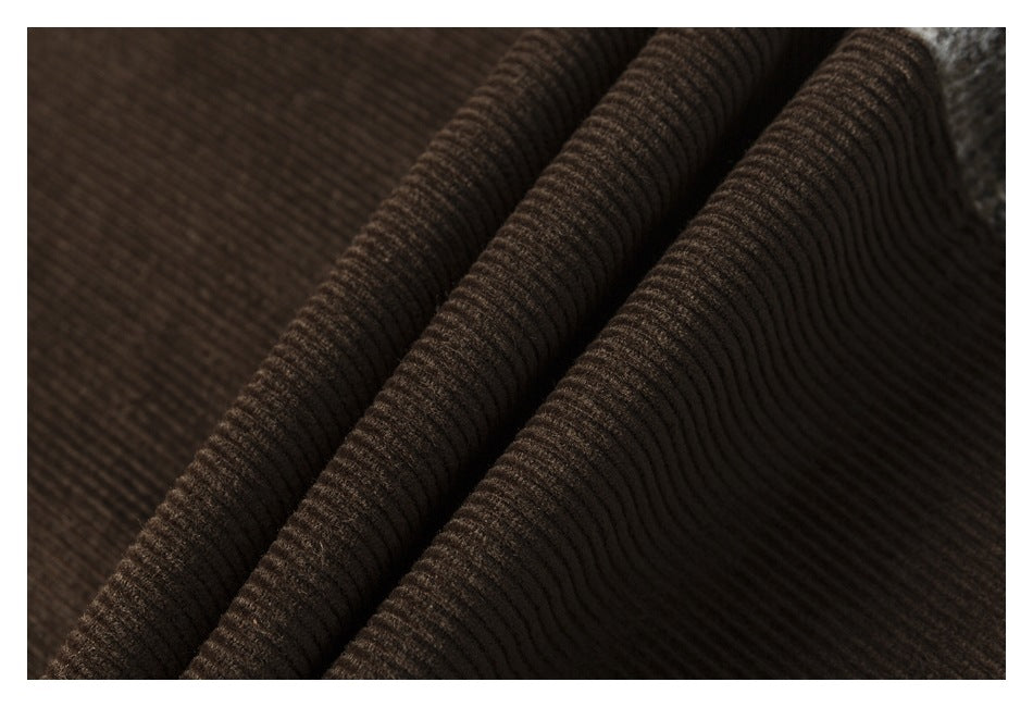 Close-up of brown corduroy folded into ridges, highlighting its ribbed texture.