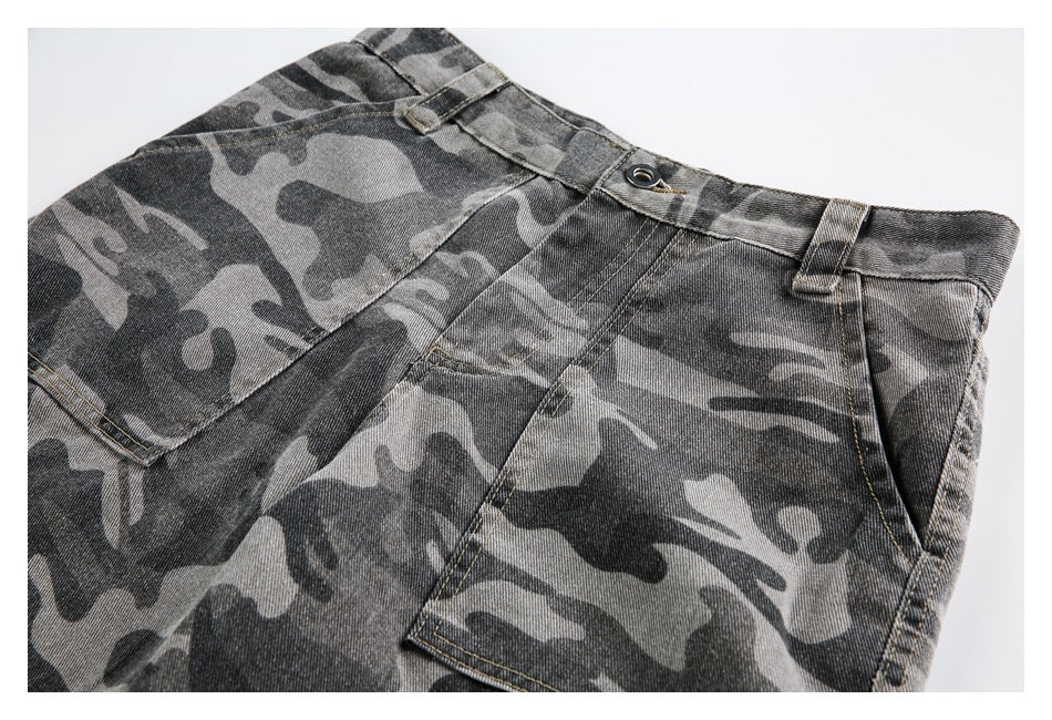 Close-up of the front waistband, button, belt loops, fly, and pocket on gray camouflage shorts.