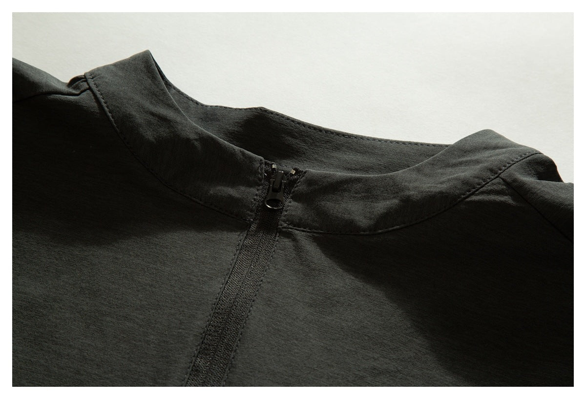 Close-up of a dark charcoal garment neckline with a short black zipper.