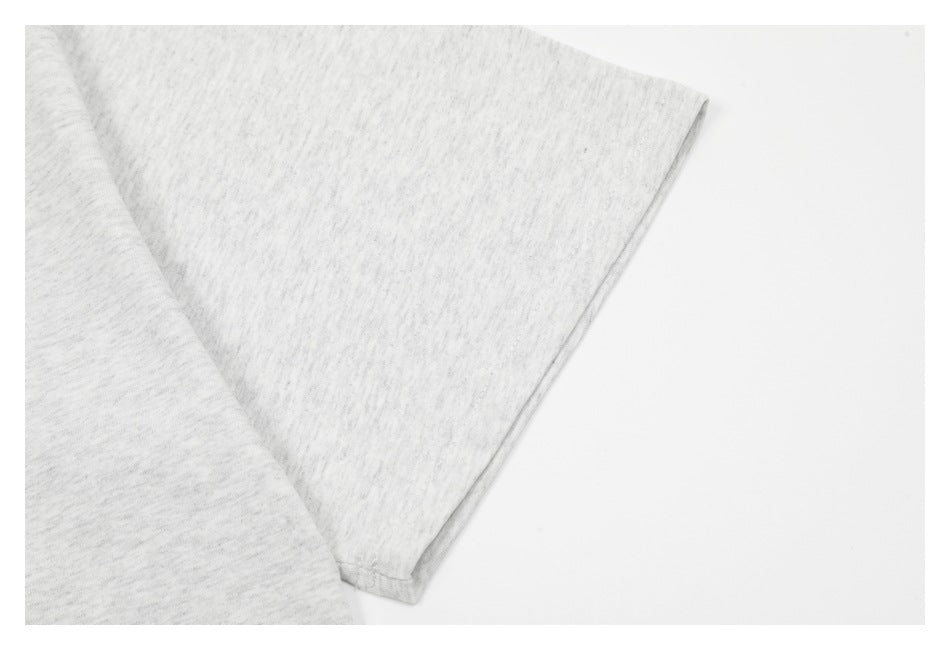 Close-up of a light gray heather T-shirt sleeve and stitched edge.