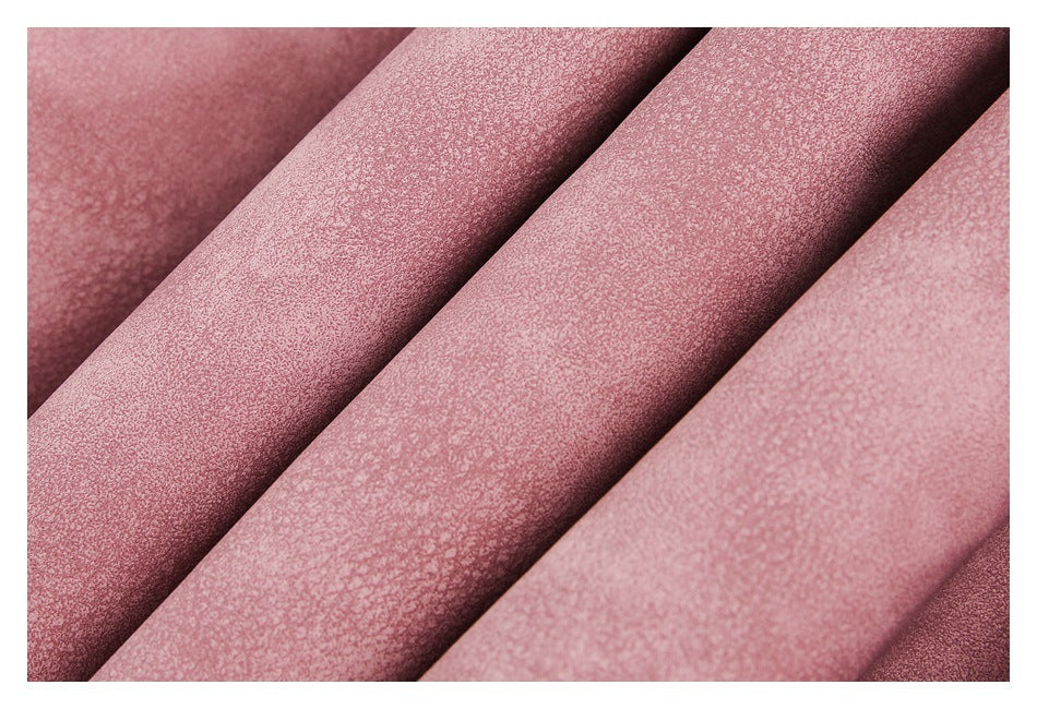 Close-up of dusty rose-pink fabric arranged in soft diagonal folds, showing a fine textured surface.