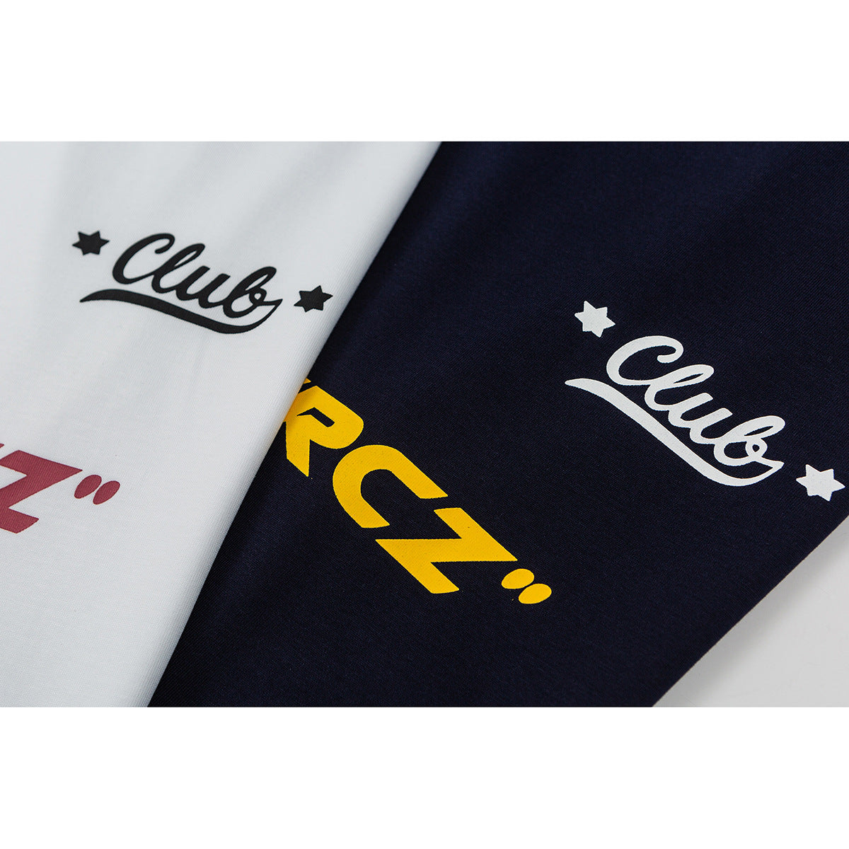 Close-up of white and navy shirt fabric with contrasting star-and-script and bold graphic prints.