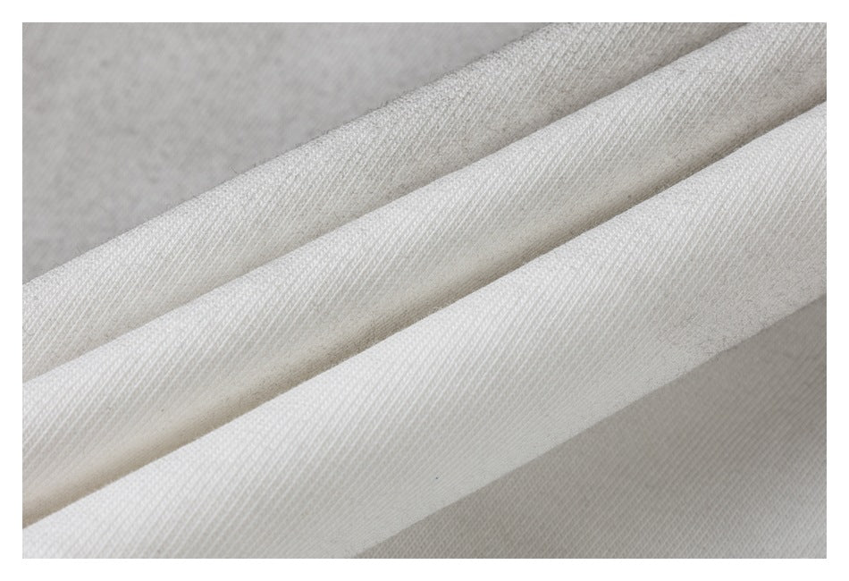 Macro view of off-white fabric folds showing a fine diagonal knit texture.