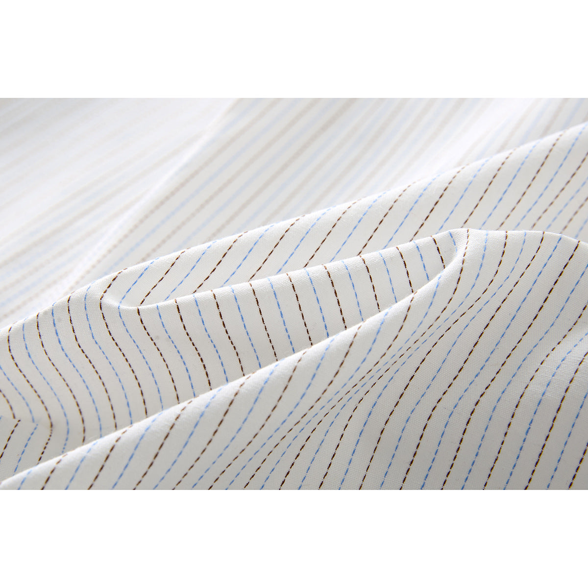 Close-up of white shirt fabric with fine blue and brown stripes and soft folds.