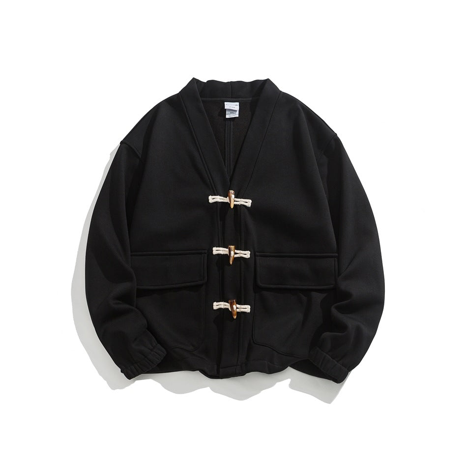 Black V-neck jacket with three cream cord toggle closures and two large flap pockets, flat lay