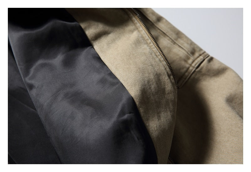 Close-up of a tan garment with a zipper beside a large black panel.