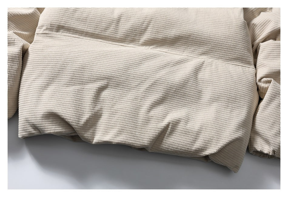 Close-up of the beige jacket's lower back and hem, with portions of the sleeves visible.