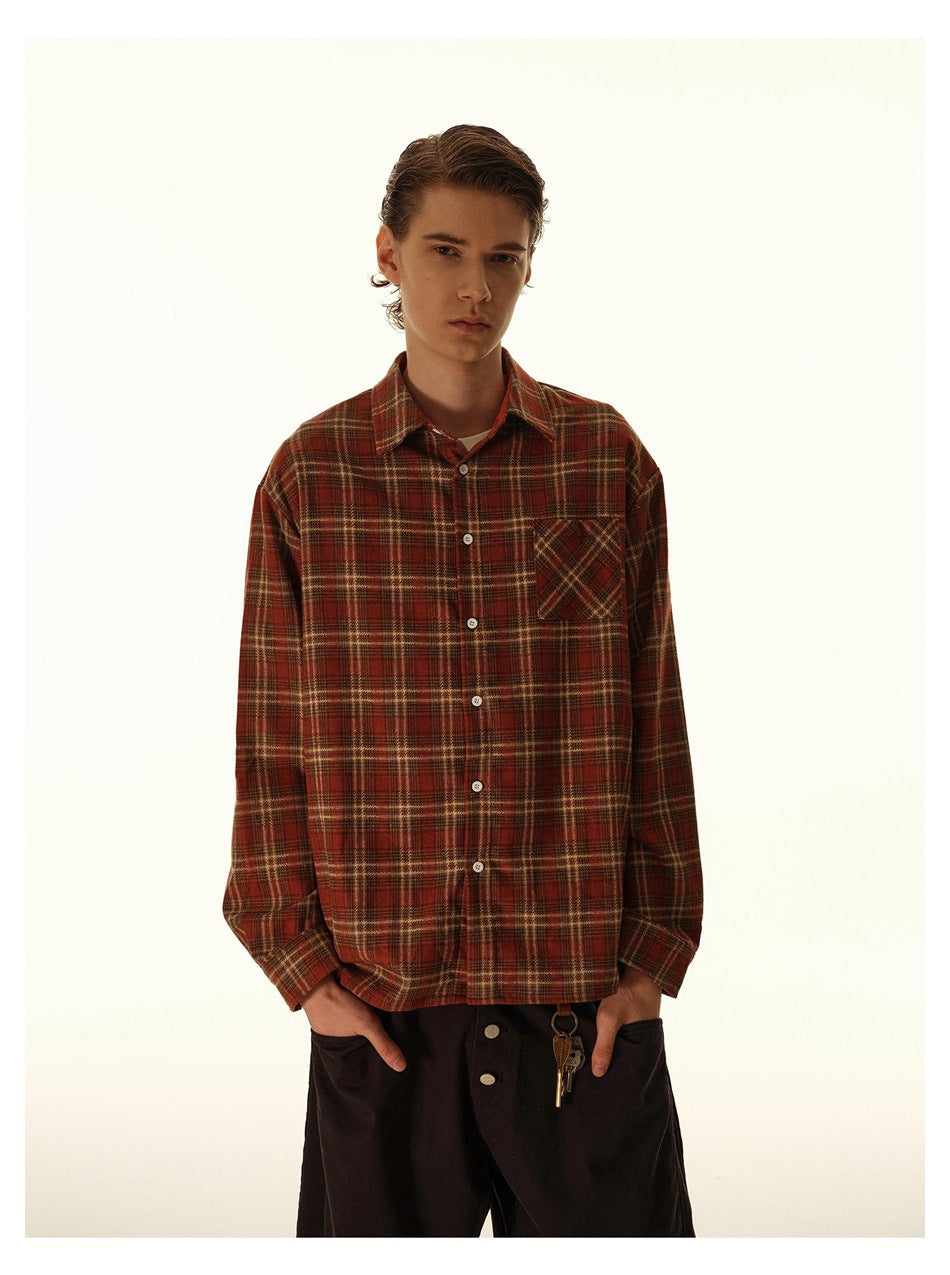 Front view of a model wearing a rust plaid button-up shirt with a chest pocket and white buttons.