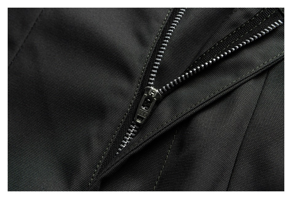 Close-up of a black garment with a partially open silver-tooth zipper.