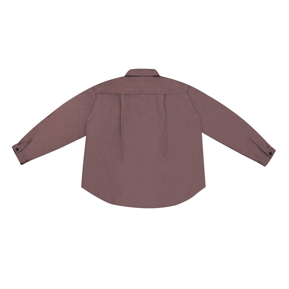 Back view of brick red long-sleeve shirt with back yoke, center pleat and button cuffs