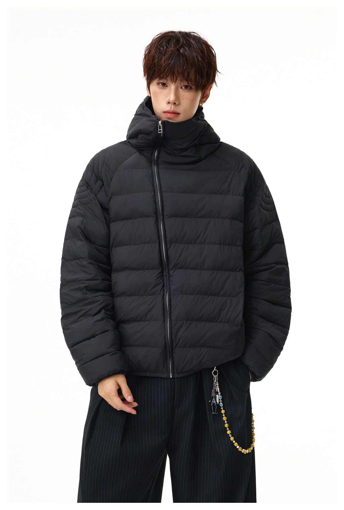 Front view of a model wearing a black quilted puffer jacket zipped to the collar.