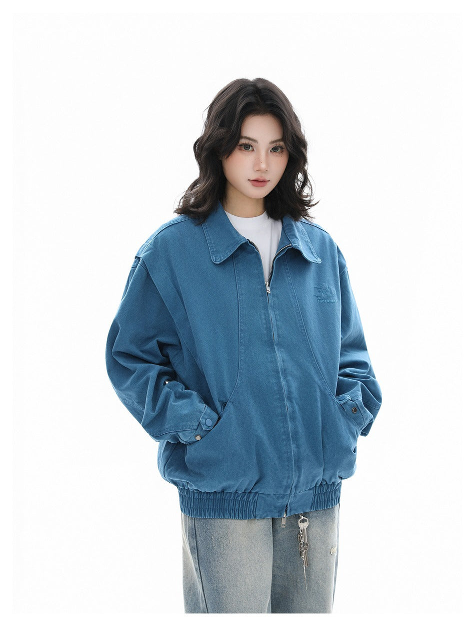 Three-quarter front view of a model wearing a blue oversized jacket with a zip front, wide collar and elastic hem.