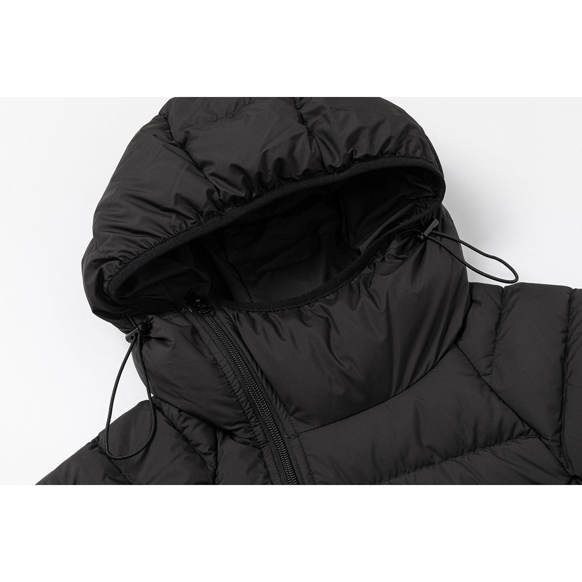 Close-up of a black quilted jacket hood with drawcords and an angled front zipper.