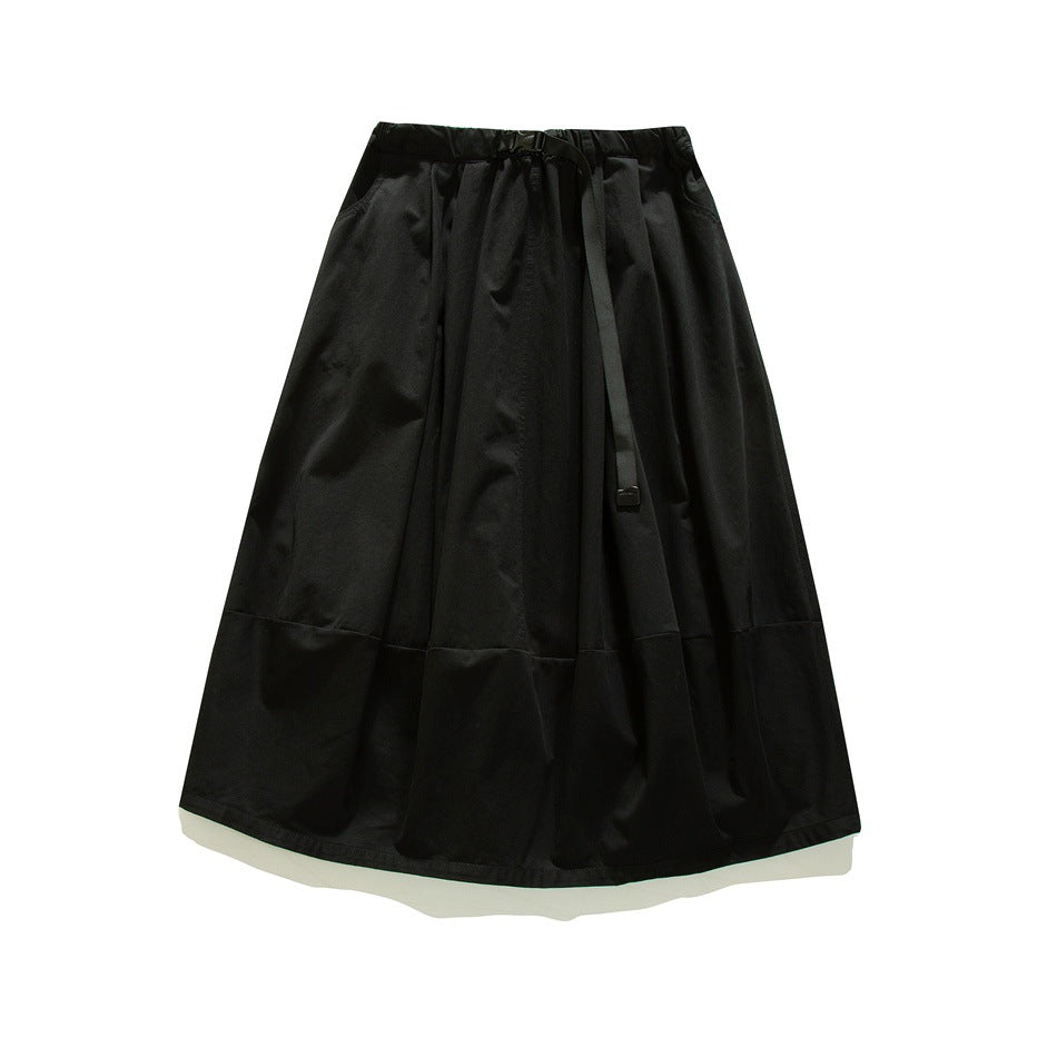 Black A-line midi skirt with elastic waist, black buckle belt and paneled hem, flat lay