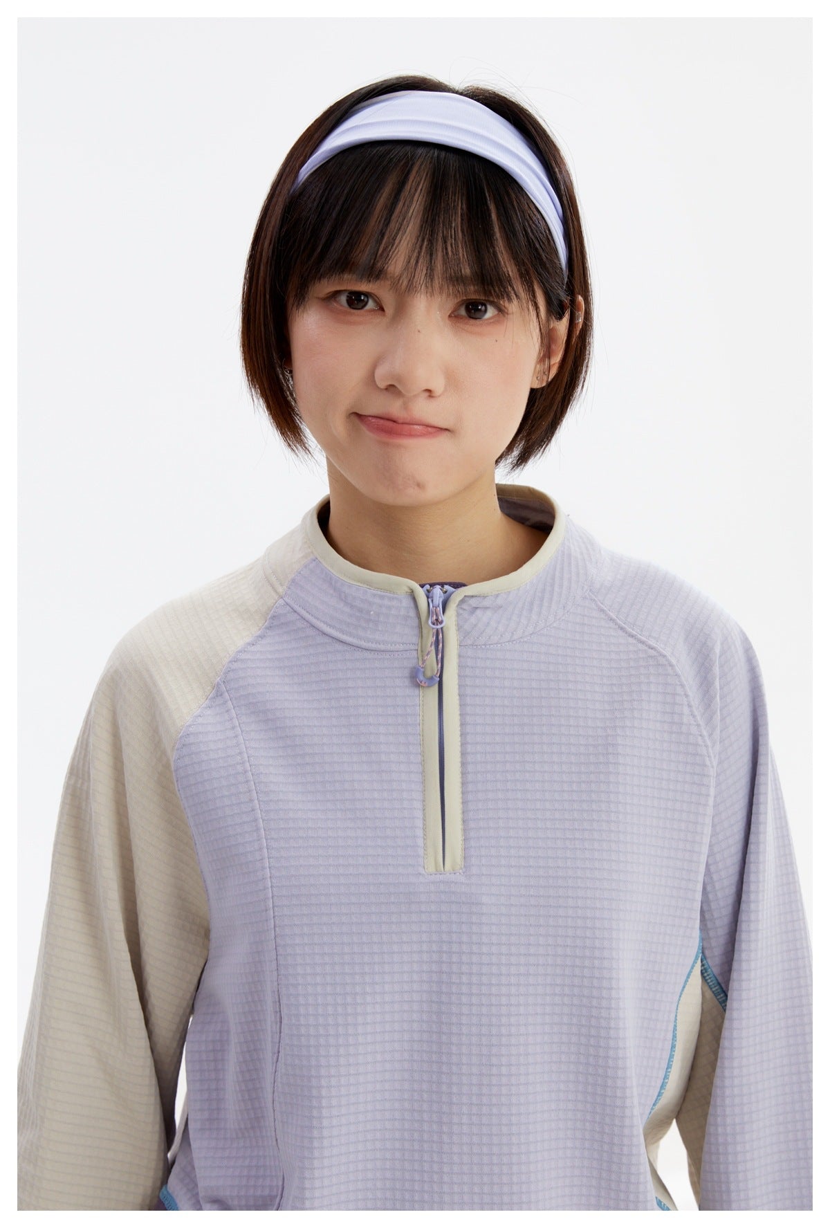 Close view of the pullover's lavender textured front, cream collar trim, and short zipper.