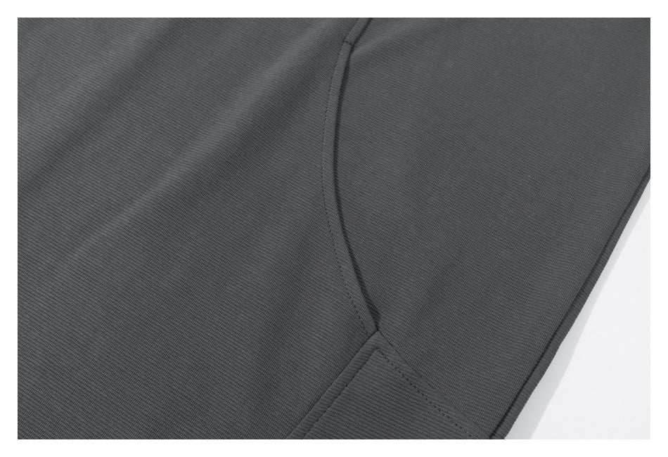 Close-up of the charcoal sweatshirt's curved side seam and lower hem.
