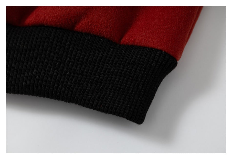 Close-up of a red jacket sleeve ending in a wide black ribbed cuff.