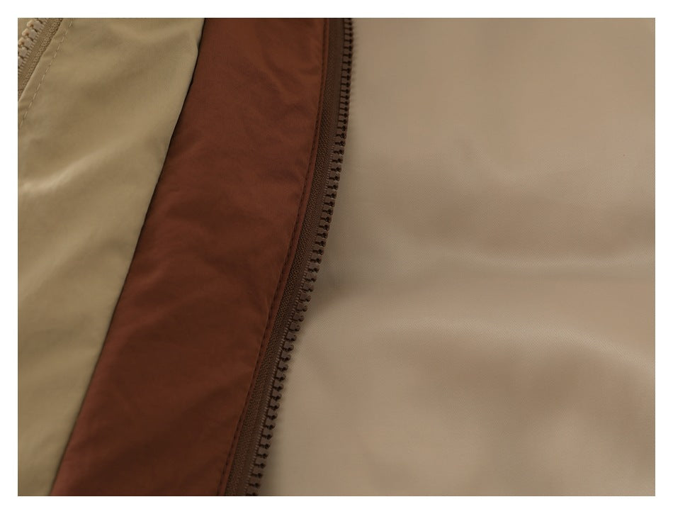 Close-up of the beige jacket's brown zipper tape and light-colored inner lining.