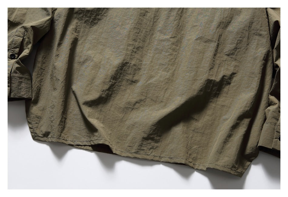 Flat view of the lower back of an olive-brown shirt with long sleeves and buttoned cuffs.