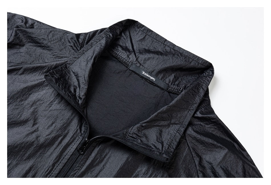 Close-up of a black jacket's high collar, zipper, and small label inside the neckline.
