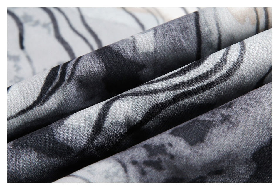 Close-up of folded gray, black, and off-white abstract-patterned fabric showing its surface and drape.