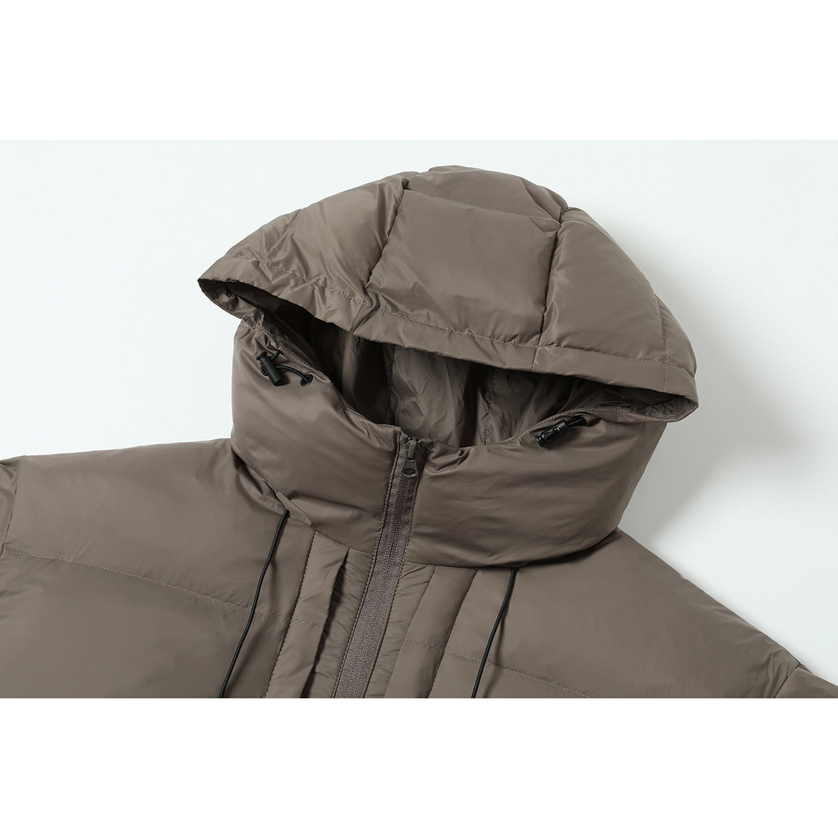 Close-up of a taupe puffer jacket’s oversized hood, drawcords, and front zipper.