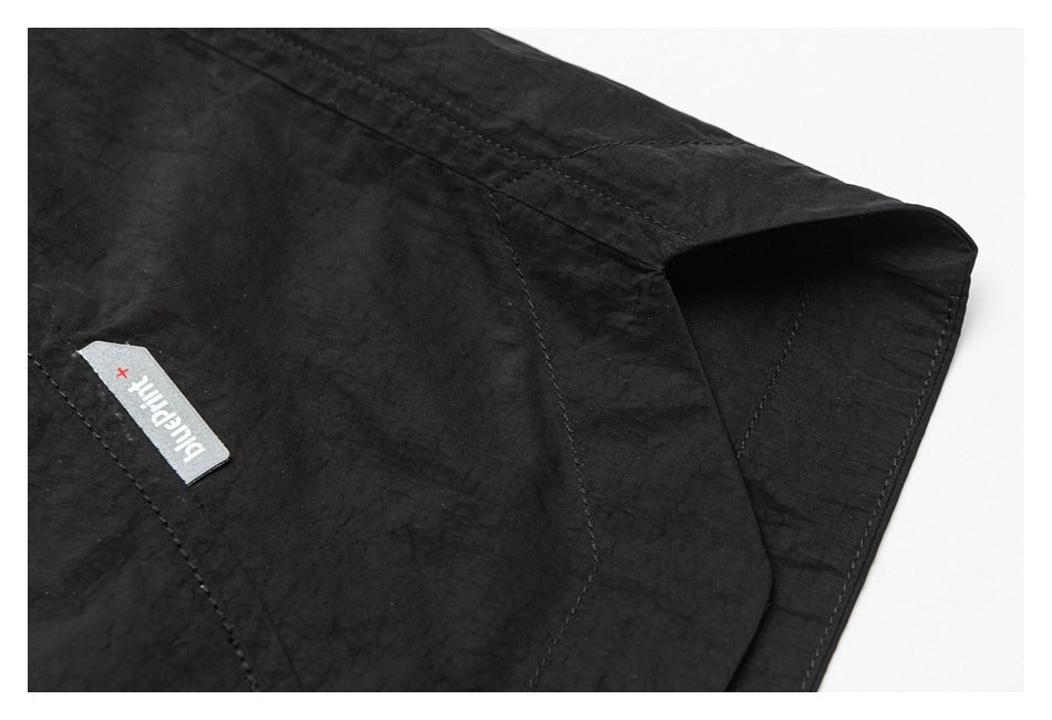 Close-up of a black garment's stitched hem and sewn bluePrint+ label.