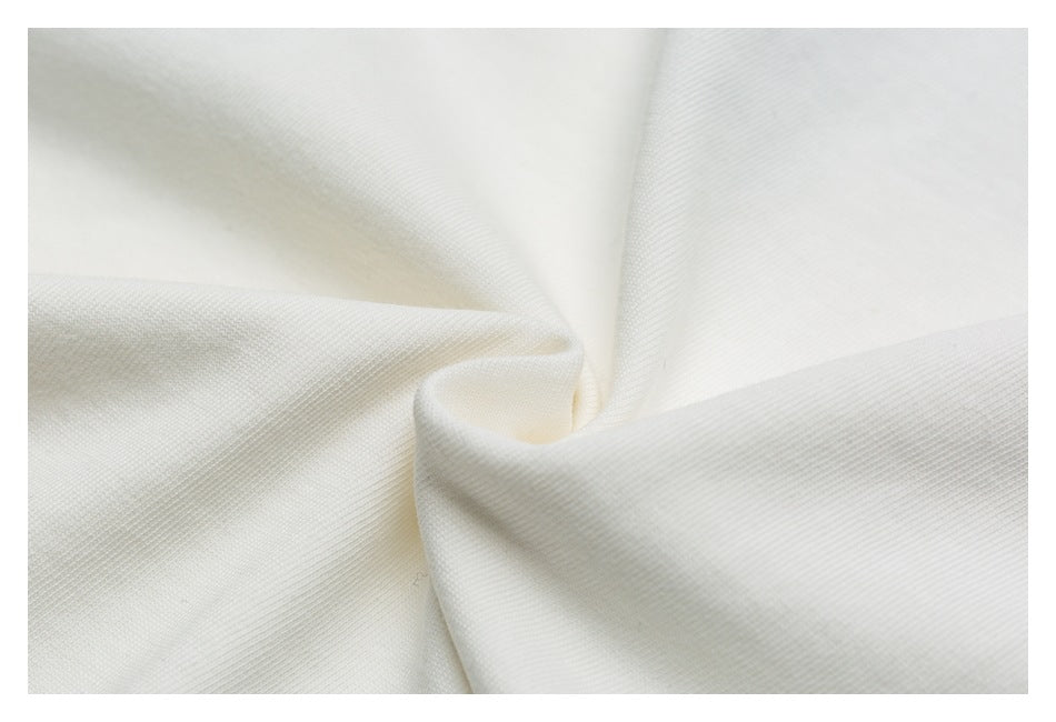 Close-up of off-white fabric gathered into a soft twist, showing its surface texture.